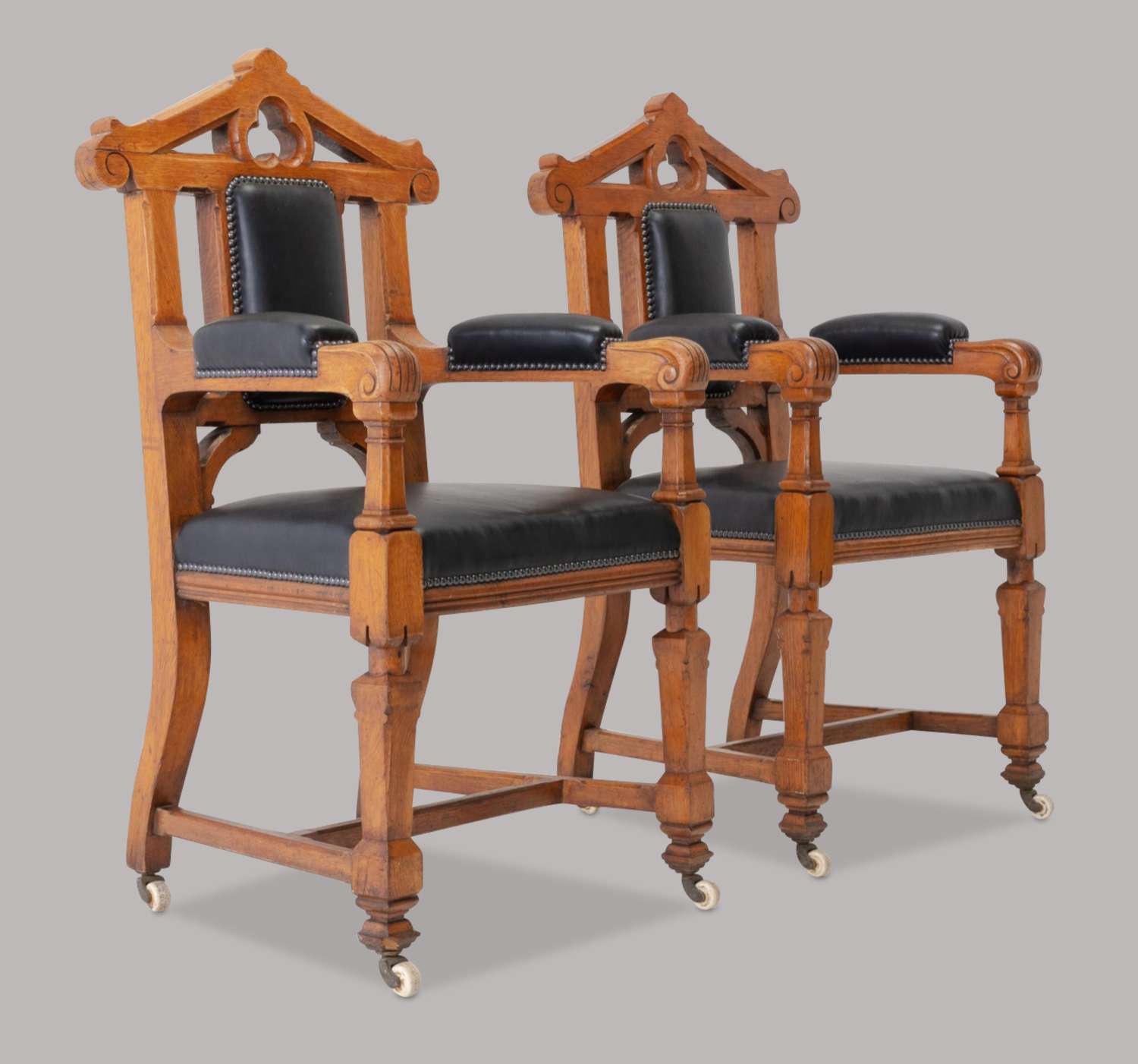 An unusual C19th pair of golden oak and leather open armchairs